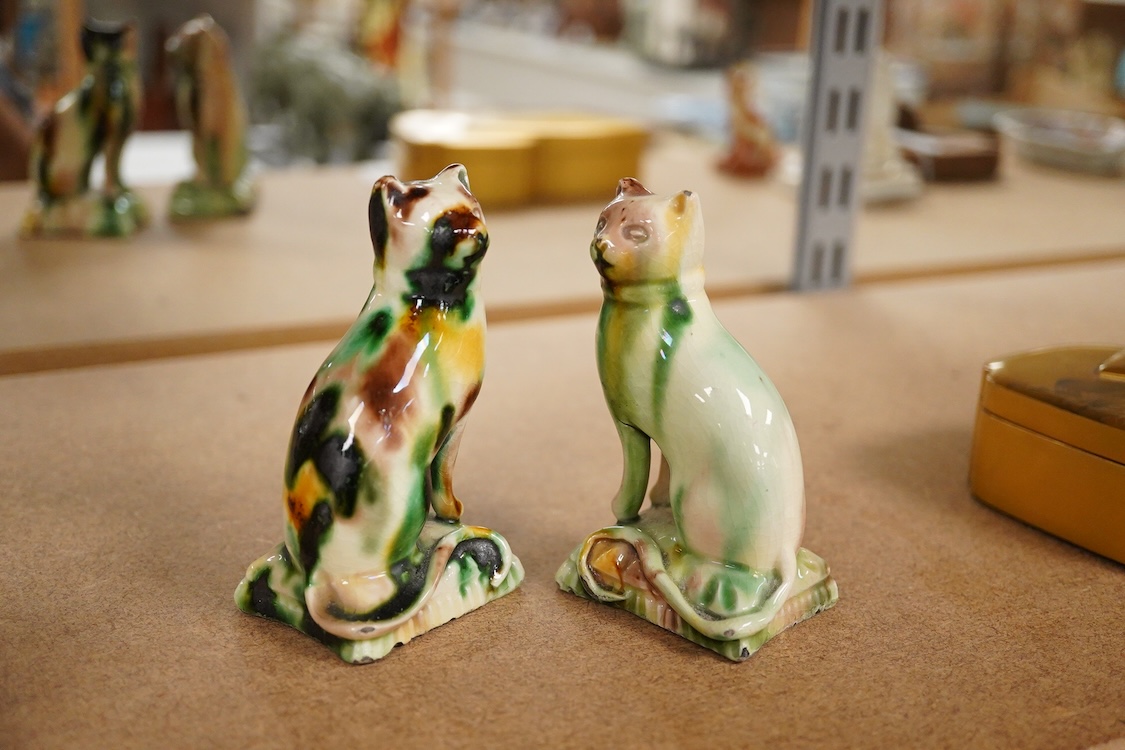A pair of tortoiseshell glazed pottery figures of cats, early 19th century, 19cm high